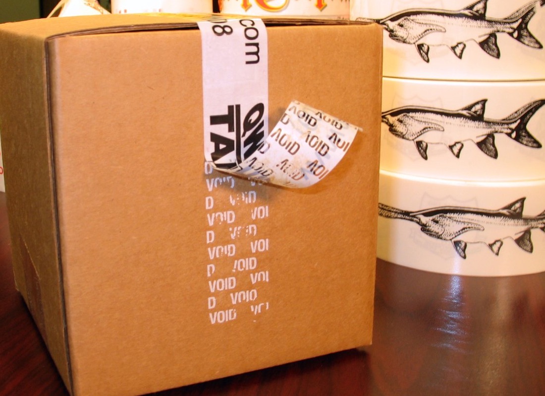 Stack of shipping boxes sealed with custom printed Qwik Tape